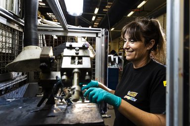 Een medewerker van BIC Graphic bedient een bedrukmachine in de fabriek.